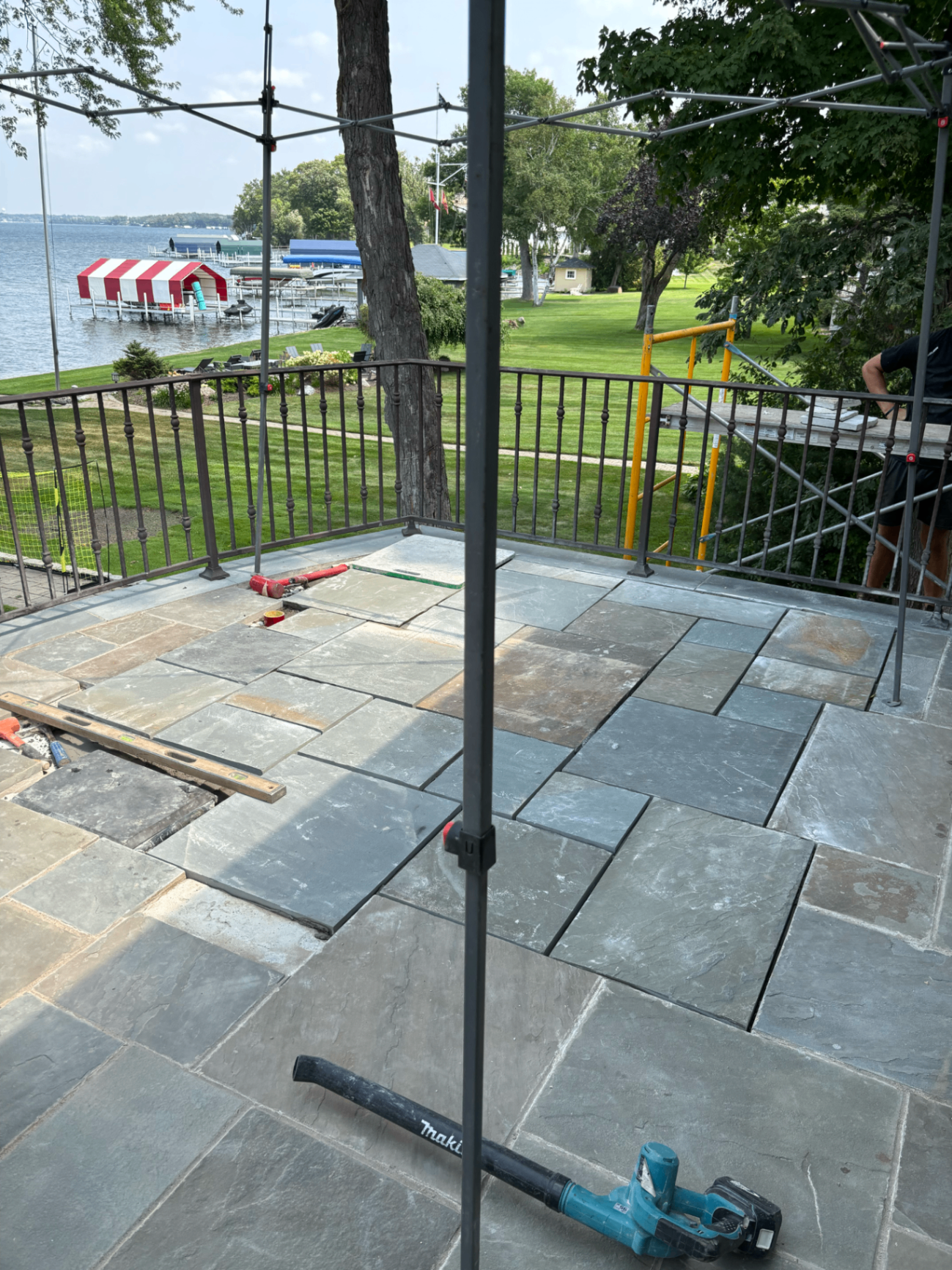 Completed lakeside stone terrace with welded railing overlooking the water